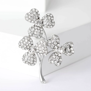 Détail macro d'une broche florale en strass sur un fond géométrique blanc élégant