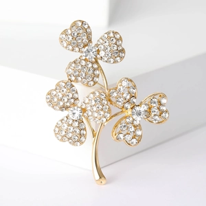 Broche fleur dorée élégante sertie de strass brillants sur des blocs blancs modernes
