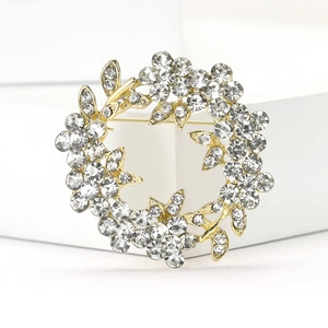 Détail d'une broche couronne plaquée or avec des cristaux brillants et des strass