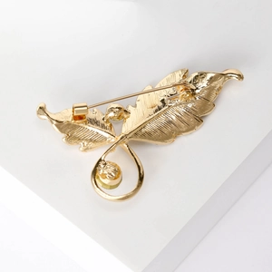 Vue arrière d'une broche feuille dorée avec texture nervurée et fermoir à épingle de sûreté
