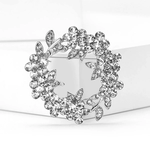 Macro de la broche couronne argentée avec strass étincelants et détails floraux fins