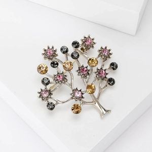 Elegant silver alloy tree brooch with colorful rhinestones on a minimalist white stage