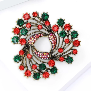 Macro view of vintage style round flower cluster brooch with red and green rhinestones