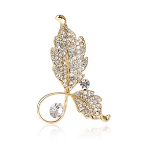 Élégante broche en forme de feuilles dorées sertie de strass et perles sur blanc