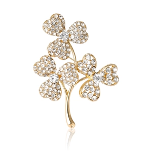 Broche trèfle élégante en or avec strass blancs et perles sur fond blanc pur