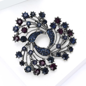 Close-up of vintage Christmas bell brooch with navy blue and purple rhinestones