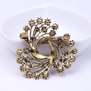 Detailed back view of vintage gold Christmas brooch with secure safety pin clasp on a dish