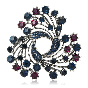 Vintage silver Christmas brooch with blue and red rhinestones on a white background