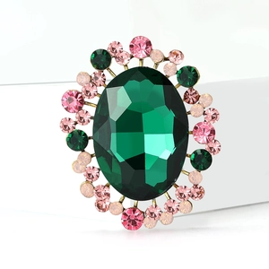 Elegant gold brooch with large oval green crystal and pink rhinestone halo details