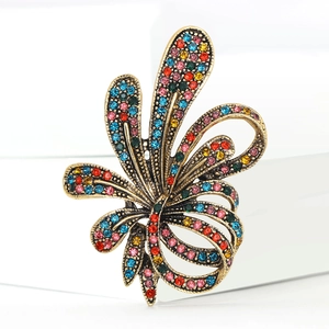 Close-up of vintage flower brooch with colorful rhinestones on a white pedestal