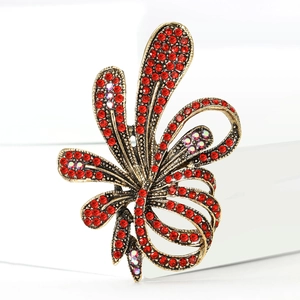 Macro detail of luxury vintage bronze flower brooch with deep red and AB color crystals