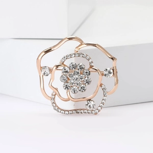 Squisita spilla a fiore in oro rosa con petali traforati e strass bianchi su base bianca