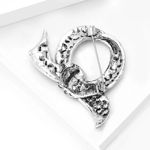 Macro shot of the vintage alloy bow brooch back featuring the secure safety pin clasp detail