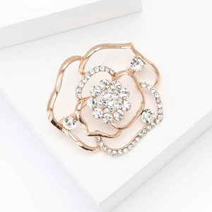 Elegante spilla a fiore traforata in oro rosa con cristalli su base in marmo bianco