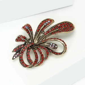 Macro shot of luxury gold-toned floral brooch with red and AB crystal rhinestones