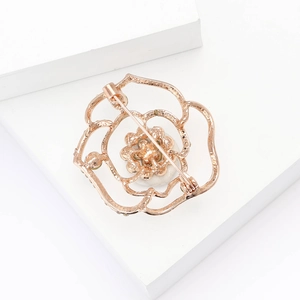 Dettaglio macro della spilla a rosa in oro rosa con perla e chiusura di sicurezza