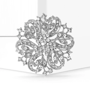 Macro shot of a luxury silver-tone flower brooch with intricate hollow metalwork and crystals