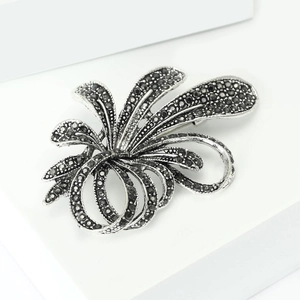 Close-up of vintage flower brooch with black rhinestones on a silver alloy base