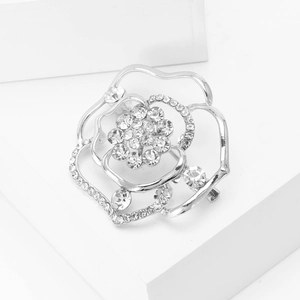 Elegante spilla a rosa argentata con strass scintillanti e petali di fiori traforati