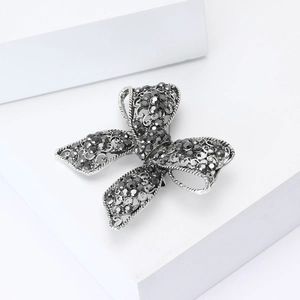 Vintage silver butterfly brooch with intricate filigree and dark grey rhinestones