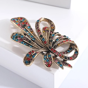 Detail of luxury alloy flower brooch with multi-color rhinestones and antique gold finish