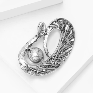 Vue détaillée du dos d'une broche vintage montrant l'épingle et la texture brossée