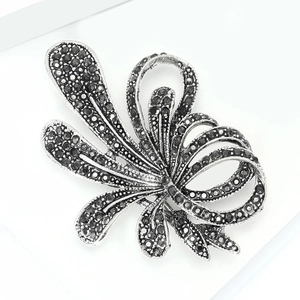 Detailed macro view of vintage silver alloy floral brooch with black sparkling rhinestones