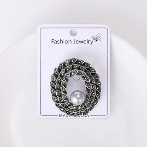 Detail view of vintage dark silver brooch with pearl and micro-inlaid dark crystals