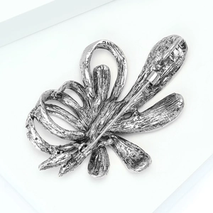 Macro detail of antique silver floral brooch showing high-quality metal back and pin clasp