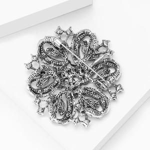 Close-up of the vintage silver floral brooch back showing secure pin fastener and texture