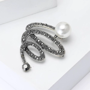 Elegante spilla vintage in metallo scuro con perla bianca e cristalli scintillanti