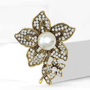 Vintage gold flower brooch with sparkling rhinestones and a large white pearl center