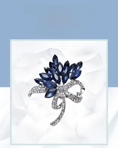 Detailed macro view of navy blue crystal brooch with silver bow and pave rhinestones