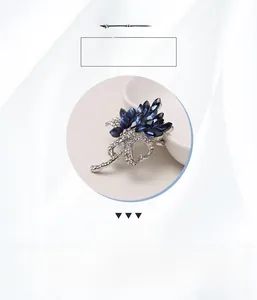 Detailed close-up of crystal bird brooch with navy blue gems and white rhinestones