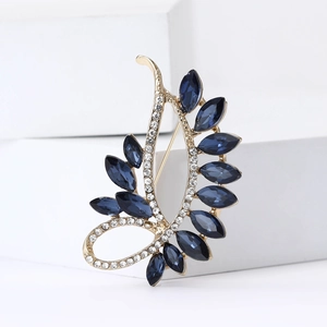 Elegant gold alloy feather brooch with blue rhinestones and crystals on white stone