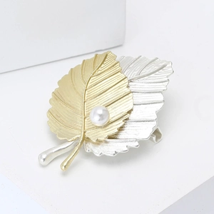 Broche feuille bicolore mate tendance avec perle sur un fond blanc épuré