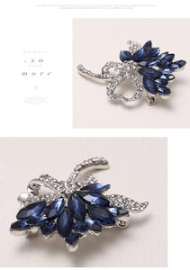 Macro detail of dark blue marquise-cut crystal brooch with silver pave diamond setting