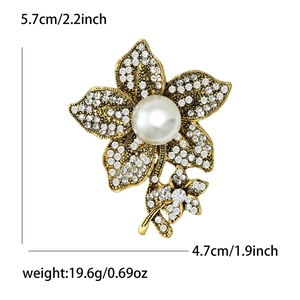 Vintage flower brooch with white crystals and large pearl set in golden alloy base