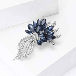 Détail macro d'une élégante broche fleur en pierres bleues et strass sur fond blanc