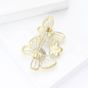 Vue arrière d'une broche papillon dorée avec fermoir à épingle et texture évidée