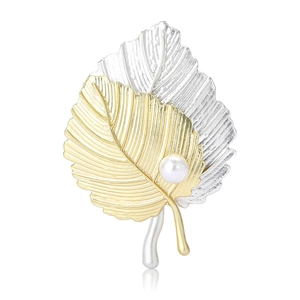 Élégante broche en forme de feuille bicolore avec perle sur fond blanc réfléchissant