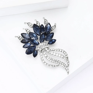 Détail de la broche fleur avec cristaux bleus et strass blancs sur une base argentée
