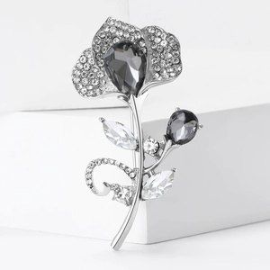 Elegant silver alloy flower brooch with black and white rhinestones on a white background