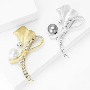 Broches ruban élégantes en or et argent mat avec perles et cristaux sur socle de pierre