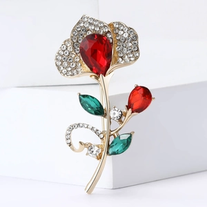 Elegant gold flower brooch with red pear-shaped crystal and sparkling white diamonds