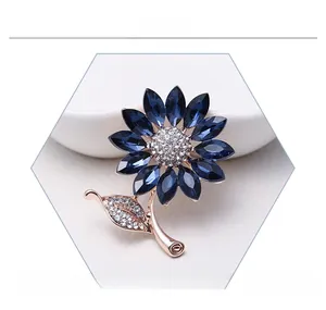 Close-up of crystal flower brooch with navy blue petals and rose gold metal finish