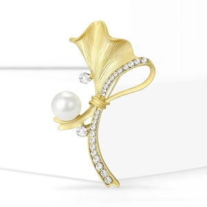 Broche plante dorée mate élégante avec une perle blanche et strass étincelants