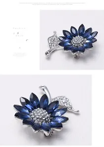 Detail of silver alloy brooch with dark blue crystal petals and micro-set white diamonds