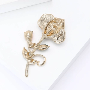 Detailed back view of golden flower brooch showing the secure pin fastener and texture