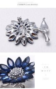 Macro view of blue crystal sunflower brooch with silver safety pin back detailing